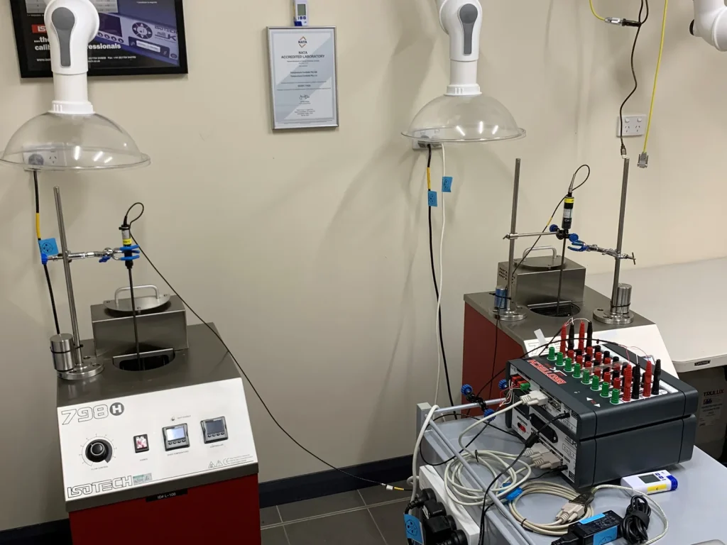 Two Isotech calibration baths in the Temperature Controls laboratory at Sefton, with the NATA accreditation certificate framed on the wall